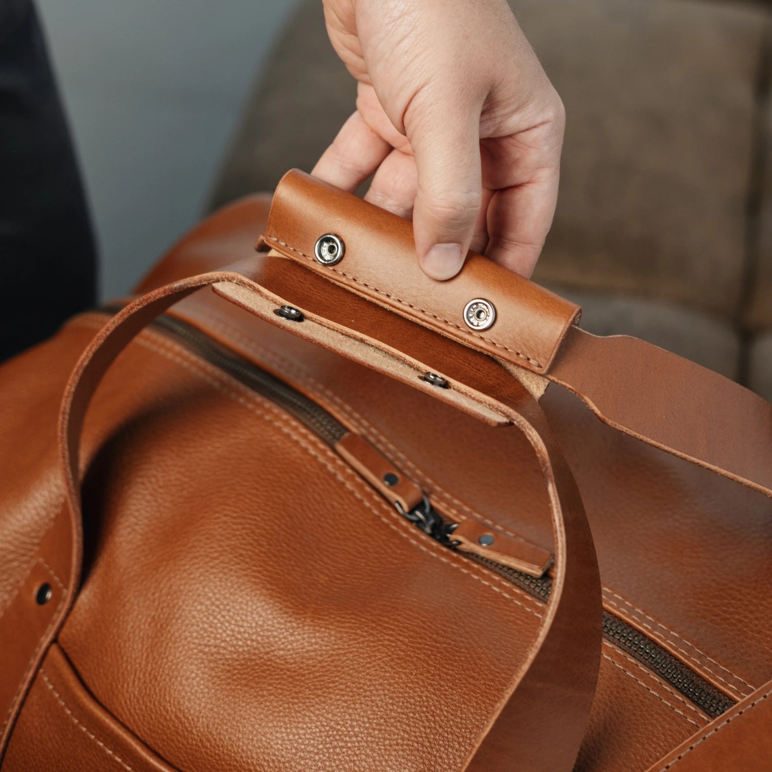 Close-up of the structured top handle with rivet detailing on the Nordweg Legacy Leather Duffel Bag in cognac