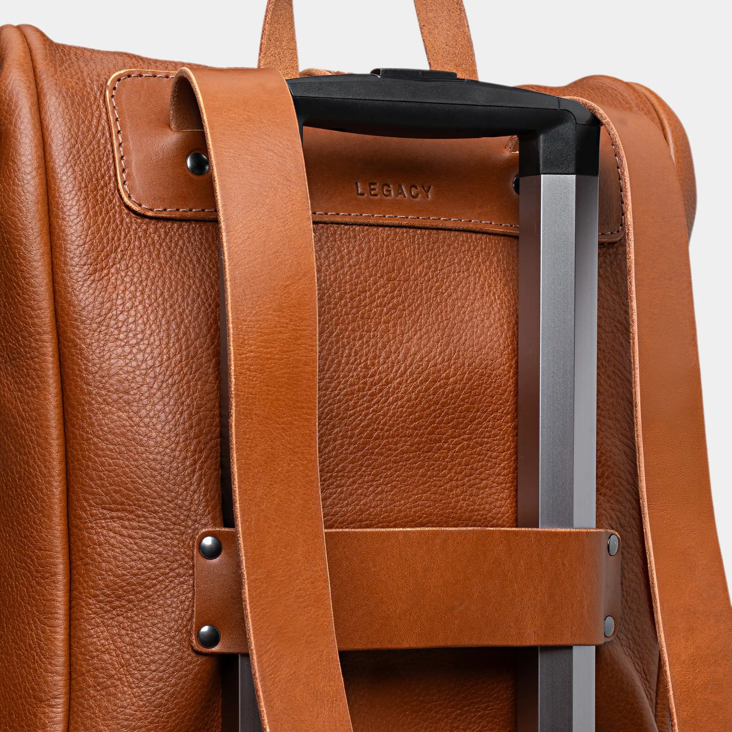 Detalhe do passador de mala da Mochila Legacy Nordweg Cognac encaixada na mala de rodinhas