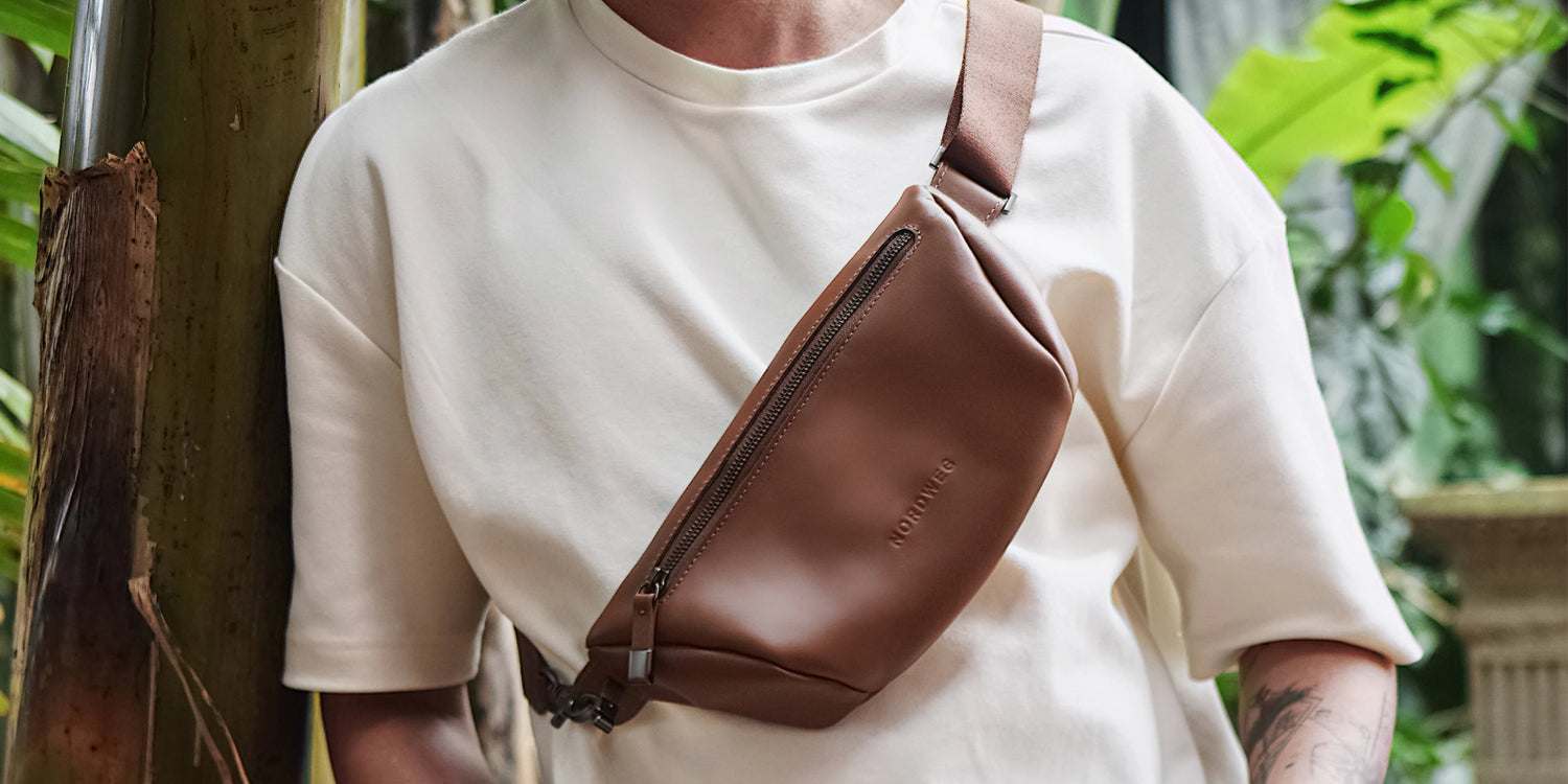 Front view of the Nordweg Pulse Leather Sling Bag in caramel worn across the chest outdoors